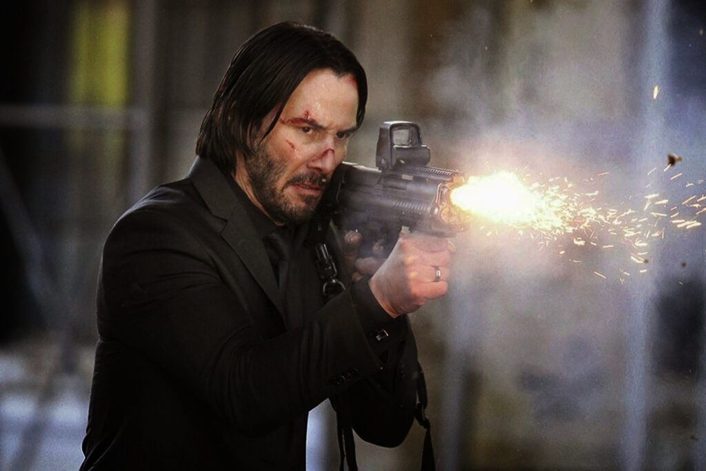 Keanu Reeves como Jonh Wick disparando una arma de fuego.